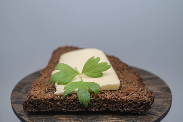 A piece of butter with herbs on toasted rye bread - Фото, зображення