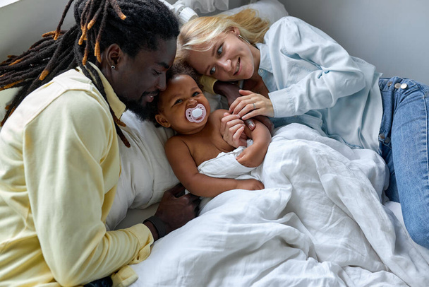 美しい多民族の家族、黒と白人の両親は娘と一緒に楽しみを持っています - 写真・画像