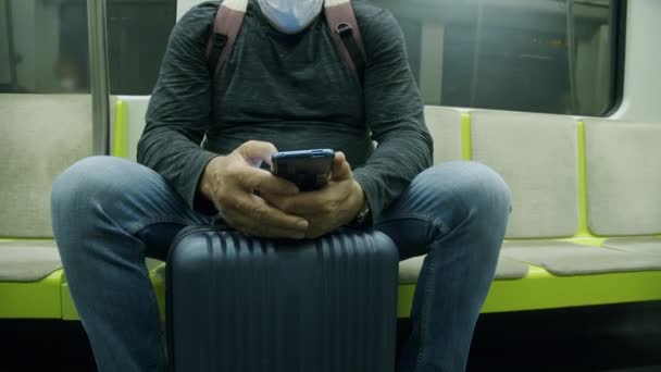 Metro treninde telefonu kullanan bavullu bir gezgin. - Video, Çekim
