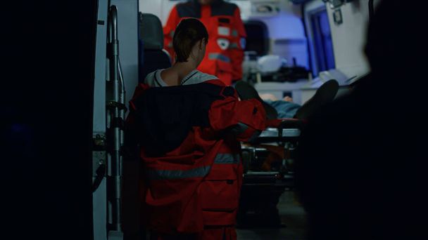 Los paramédicos rescatan al paciente después de un accidente de coche. Médicos transfiriendo al hombre - Foto, imagen