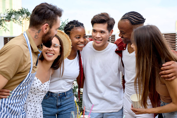 Positive excited multiracial young women and men having fun together outdoor. - 写真・画像