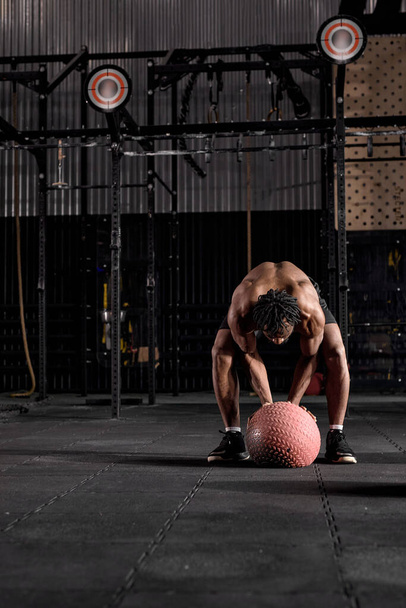 Muscular athletic man exercise with medicine ball at health club or gym. - 写真・画像