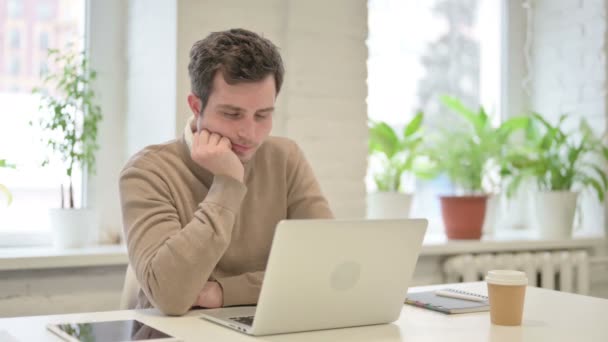 Fáradt férfi szundikál, miközben ül az irodában laptoppal - Felvétel, videó