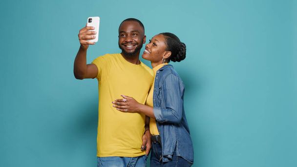 Radostní lidé pomocí mobilního telefonu, aby se Selfies dohromady ve studiu - Fotografie, Obrázek
