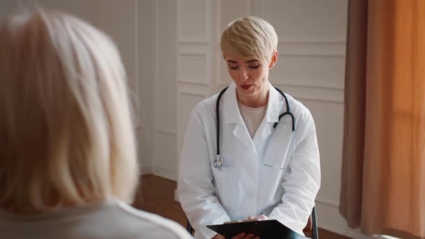 Mujer Doctor Consulting Senior Paciente Mujer Durante la cita médica en interiores - Imágenes, Vídeo