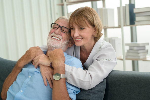 Happy Caucasian senior couple relaxing in living room  at home - Photo, image