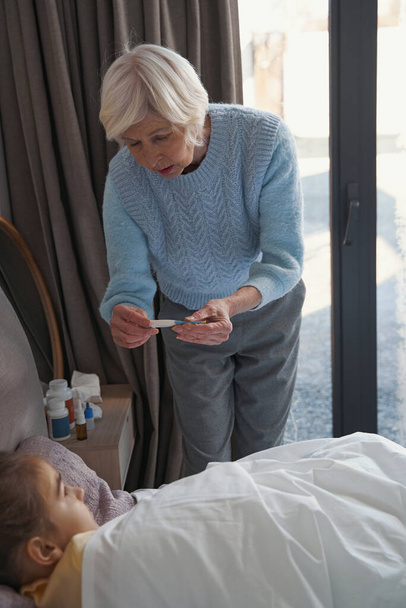 Senior lady nursing sick kid back to health - Fotografie, Obrázek