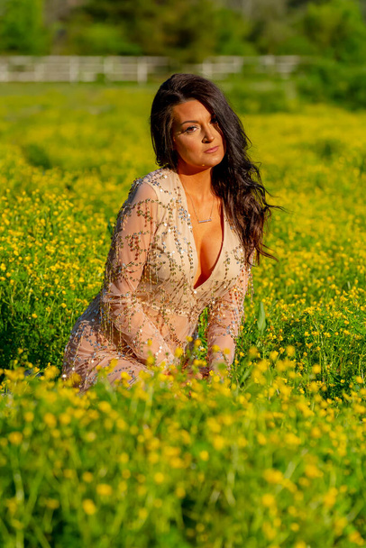 Een prachtig brunette model poseert in lingerie buiten onder het genot van het voorjaar weer - Foto, afbeelding
