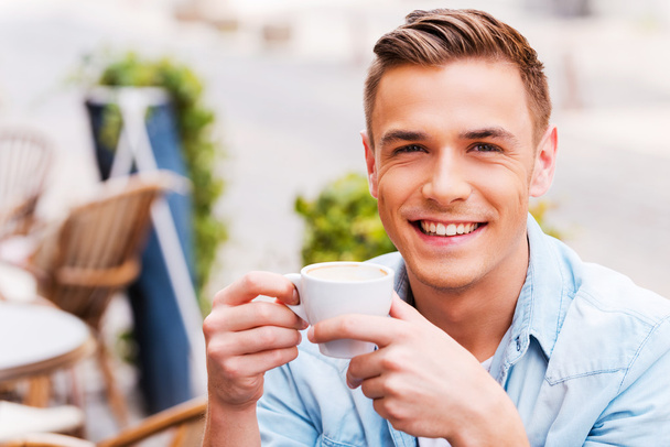 Man drinking coffee in sidewalk cafe - Foto, imagen