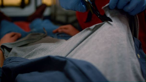 Mentős kezek vágás beteg ruhák ollóval, hogy orvosi segítséget - Fotó, kép