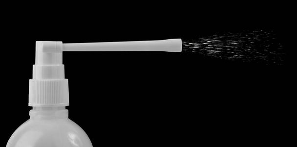 flacon en plastique blanc d'un médicament avec un flacon pulvérisateur, isolé sur fond noir - Photo, image