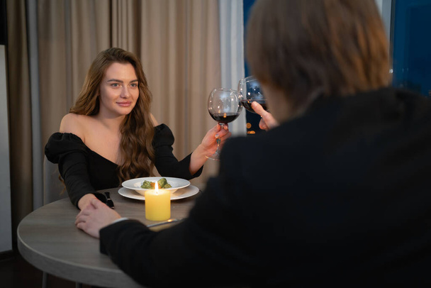 Slavit Valentýna, romantické rande páru s sklenicemi červeného vína, slavnostní večeře k výročí svatby, milenci zamilovaní doma večer, Valentýnský oslavný koncept - Fotografie, Obrázek
