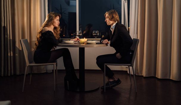 Romantic date dinner for two Valentine's Day, lovers at the table for an anniversary, candles and wine at home on the table, young family have dinner together, Valentine's day celebration concept - Fotografie, Obrázek