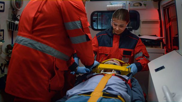 EMS παραϊατρικό προσωπικό που παρέχει τη διαδικασία πρώτων βοηθειών στον ασθενή σε όχημα έκτακτης ανάγκης - Φωτογραφία, εικόνα