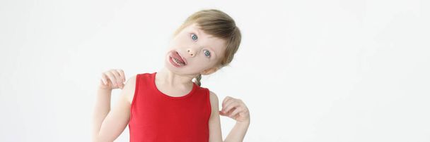 Маленькая забавная девчонка валяет дурака и показывает язык - Фото, изображение