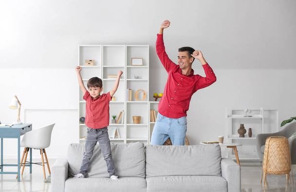 Чоловік і його маленький син танцюють вдома. - Фото, зображення