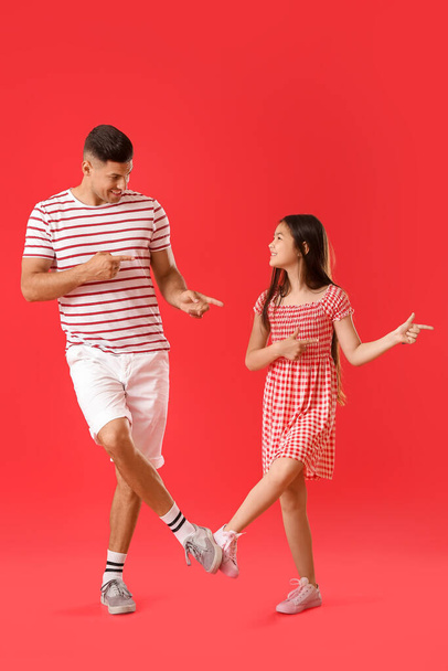 Tančící muž a jeho malá dcera na barevném pozadí - Fotografie, Obrázek