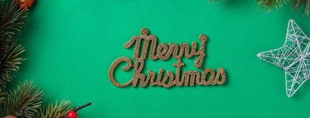 Top view of Christmas background design concept with fir tree branch and decorations on green table background. - 写真・画像