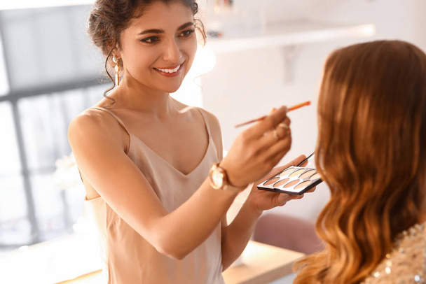 Makeup artist working with beautiful model in beauty salon - Фото, зображення