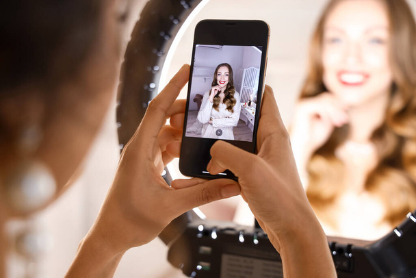 Woman taking photo of beautiful model in makeup room - Foto, afbeelding