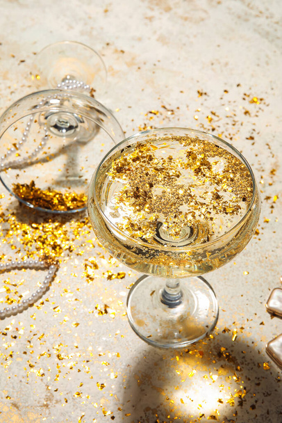 Copo de champanhe e confete dourado sobre fundo claro - Foto, Imagem