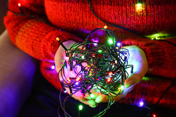 Woman holding beautiful Christmas lights, closeup - Foto, Imagem