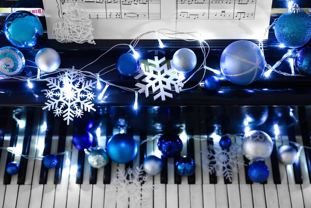 Klavír s krásným vánočním dekorem, svítící světla a poznámkové bloky, detailní záběr - Fotografie, Obrázek