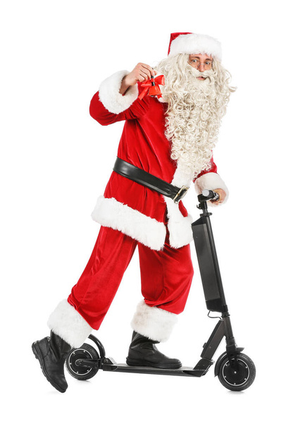 Santa Claus with Christmas bell and electric bike on white background - Photo, Image