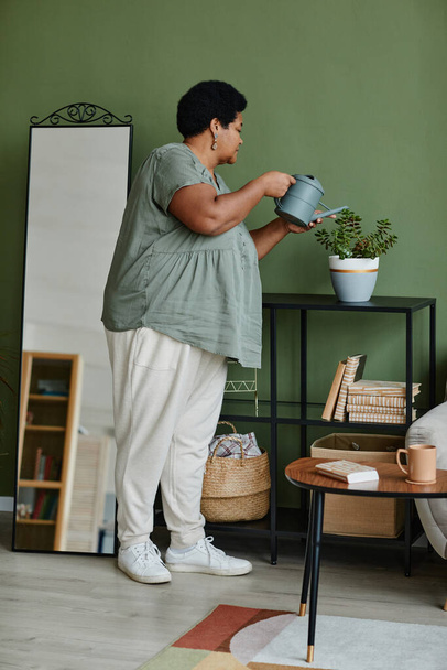 Black Senior Woman Watering Plants at Home - Photo, Image