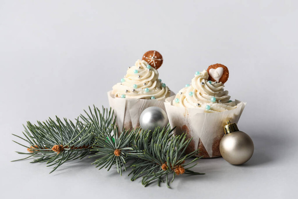 Delicious Christmas cupcakes and decor on light background - Photo, Image