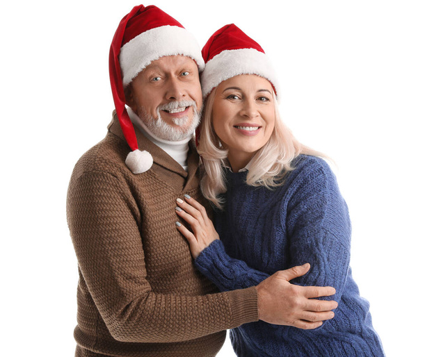 Happy mature couple in Santa hats on white background - Photo, Image