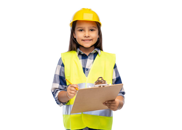 niña en casco de construcción con portapapeles - Foto, imagen