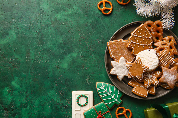 Plate with delicious Christmas cookies on green background - Foto, Bild