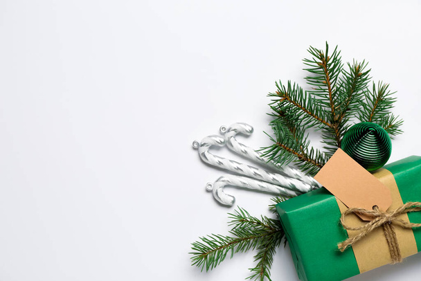 Composizione con regalo di Natale, decorazioni e rami di abete su sfondo bianco - Foto, immagini