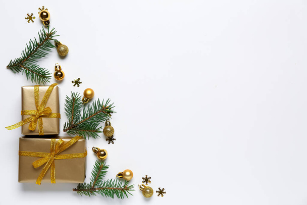 Όμορφη χριστουγεννιάτικη σύνθεση με διακοσμήσεις, κλαδιά ελάτης και δώρο σε λευκό φόντο - Φωτογραφία, εικόνα