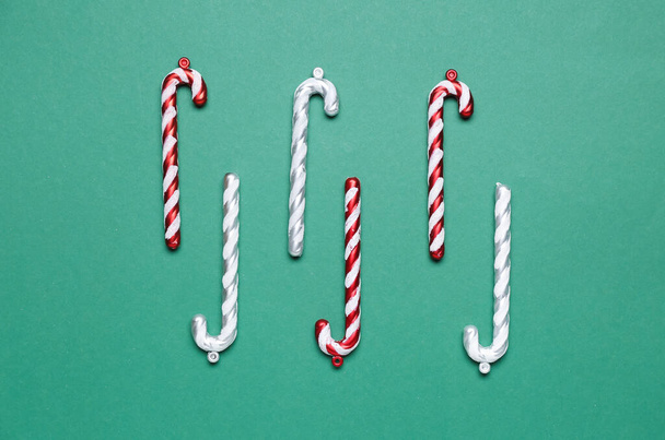 Christmas decorations in shape of candy canes on green background - Foto, afbeelding
