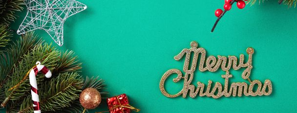 Top view of Christmas background design concept with fir tree branch and decorations on green table background. - Photo, Image