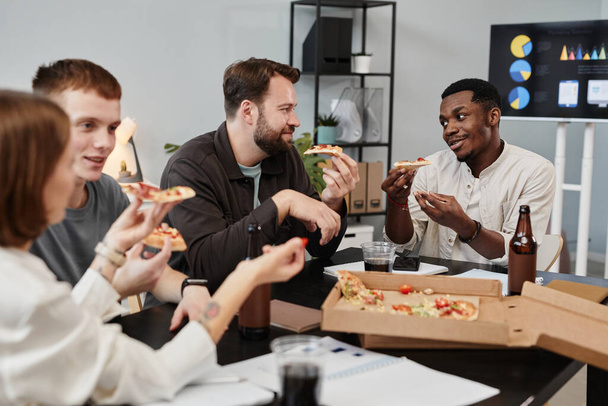 Colleagues eating pizza at office - Foto, afbeelding
