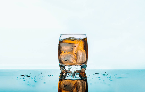 Eine Nahaufnahme eines Glases Whiskey mit Eis auf weißem Hintergrund - Foto, Bild