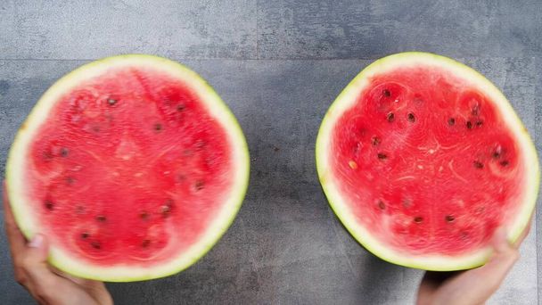 cut the watermelon into pieces and put it on a white plate - Фото, изображение