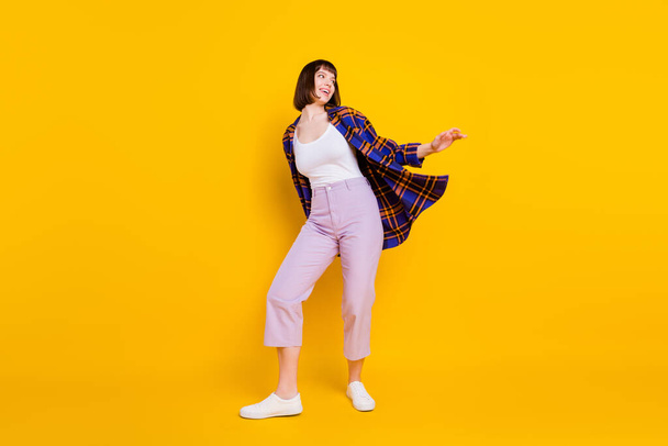 Full length body size view of attractive cheerful dreamy girl dancing rest free time isolated over bright yellow color background - Foto, afbeelding