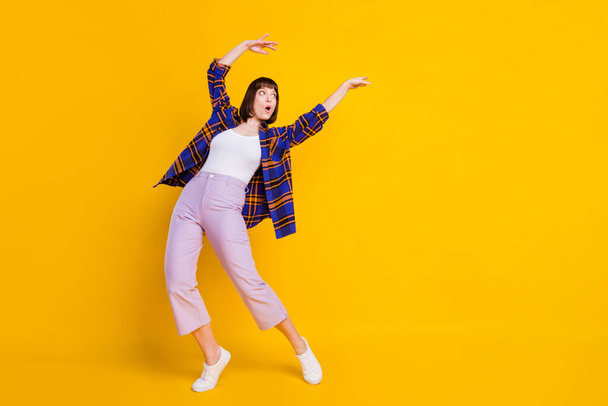 Full length body size view of pretty amazed girl dancing having fun clubbing fooling isolated over bright yellow color background - Fotoğraf, Görsel