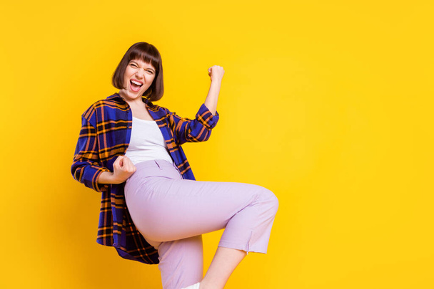 Портрет привабливої щасливої веселої дівчини, яка радіє, розважаючись ізольовано на яскраво-жовтому кольоровому фоні
 - Фото, зображення