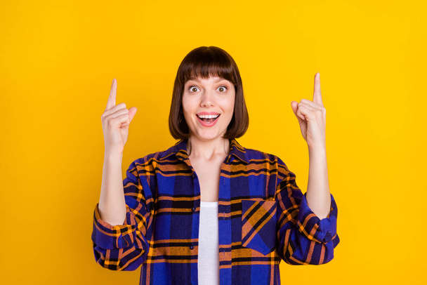 Portrait of pretty cheerful amazed girl demonstrating up copy space ad idea isolated over bright yellow color background - Фото, зображення