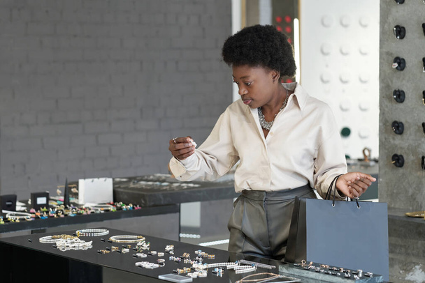 Mladý africký spotřebitel stojící na velkém displeji s šperky - Fotografie, Obrázek