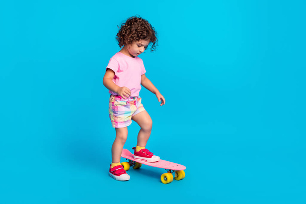 Full length body size view of nice girl learning riding skate pastime isolated over bright blue color background - Valokuva, kuva