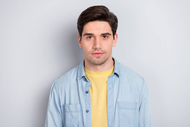 Photo of serious confident attractive young guy dressed denim shirt isolated grey color background - Foto, immagini