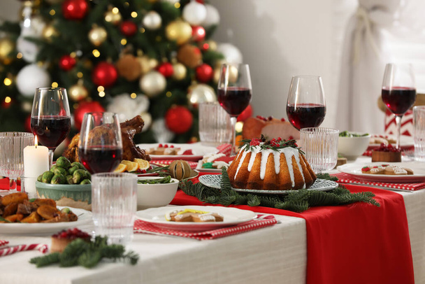 Festive dinner with delicious food and wine on table indoors. Christmas Eve celebration - Foto, Bild