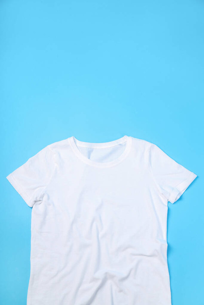 Camiseta blanca en blanco con espacio para imprimir sobre fondo azul - Foto, Imagen