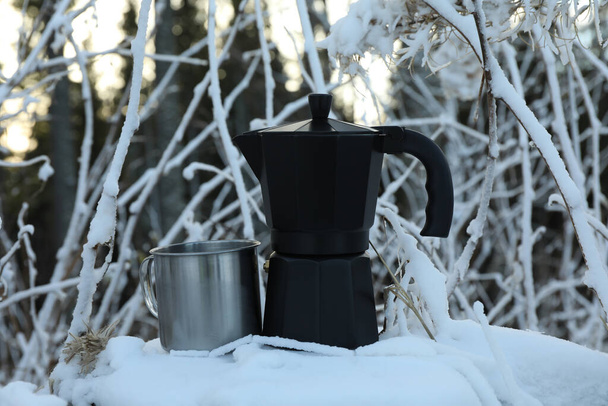 Coffee maker and metal cup on stump in winter day - Photo, image